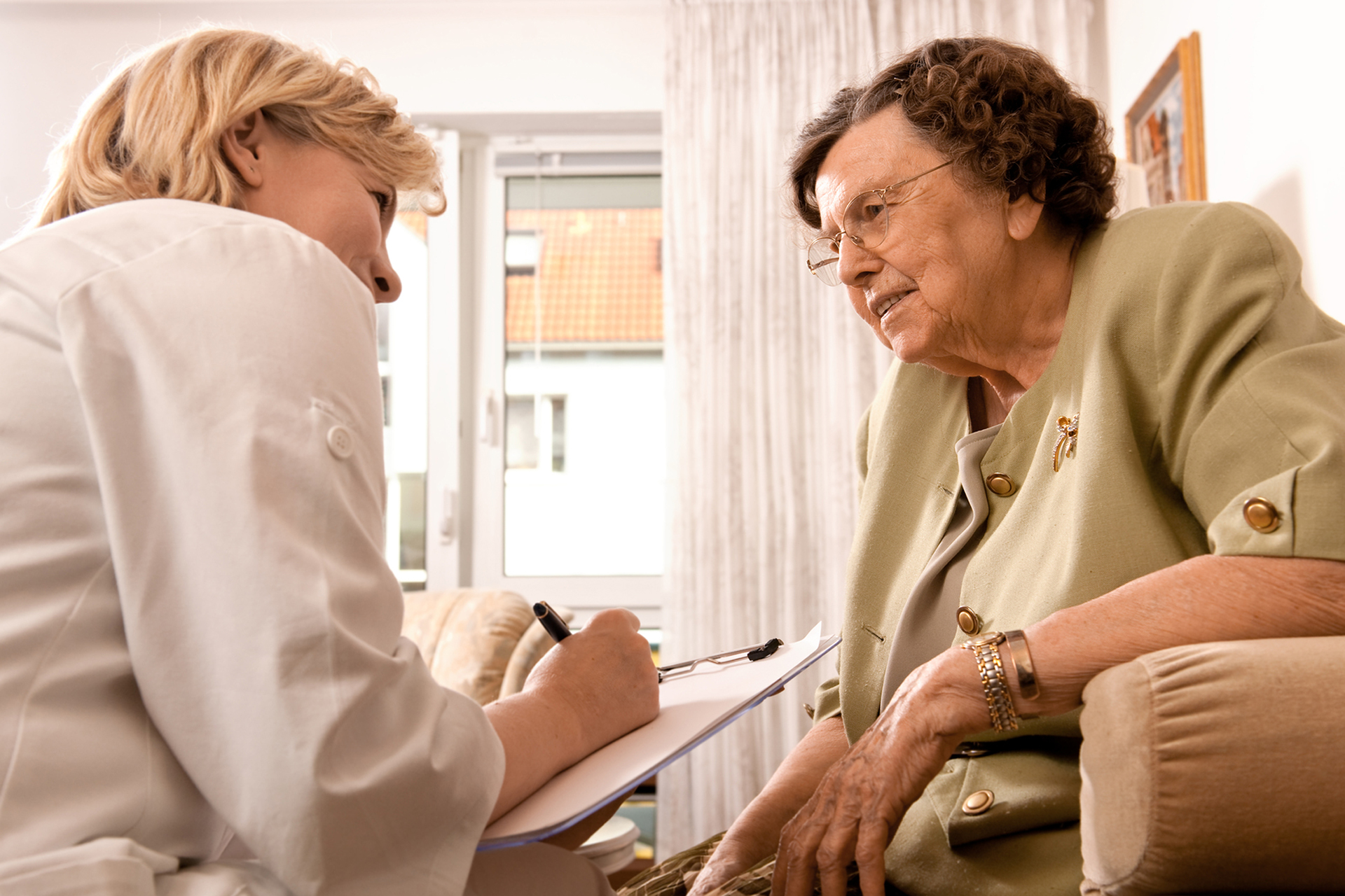 Senior woman is visited  by her doctor or caregiver at home